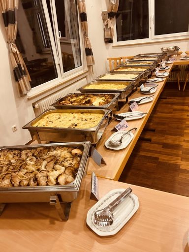 Buffet mit verschiedenen warmen Gerichten in mehreren Chafing Dishes.