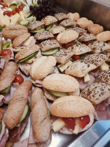 Eine Auswahl von belegten Brötchen mit verschiedenen Füllungen, darunter Gemüse und Aufschnitt.