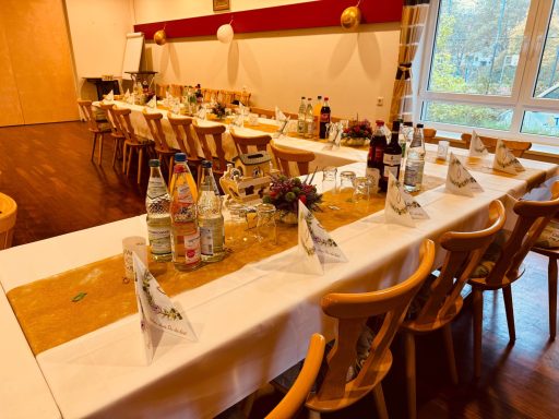 Festlich gedeckter Tisch mit Getränken und Dekoration in einem Gastraum.