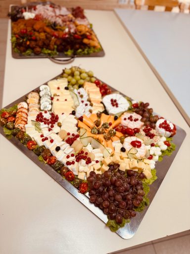 Platte mit Käse, Trauben, Nüssen, Trockenfrüchten und Oliven.