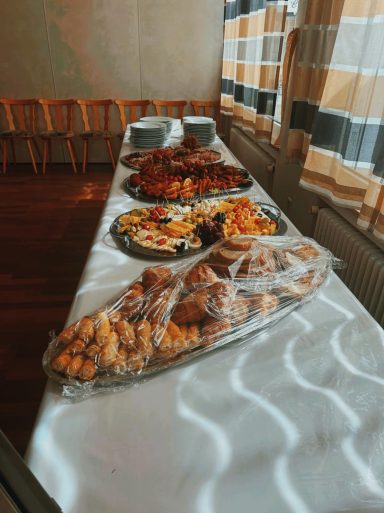Tisch mit verschiedenen Gerichten und Snacks, abgedeckt und dekoriert.