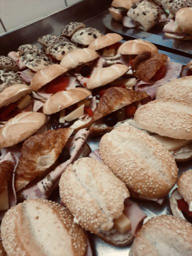 Eine Auswahl an belegten Brötchen mit verschiedenen Belägen auf einem Blech.