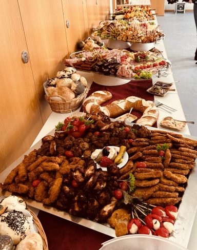 Tisch mit einer Vielzahl von Gebäck, Süßigkeiten und Snacks, dekoriert mit Früchten.